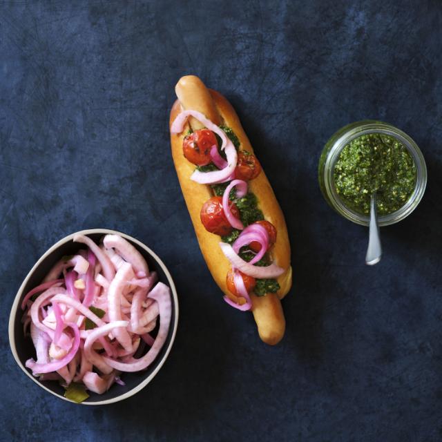 Hotdog med bagte tomater, salsa verde og syltede rødløg med fennikel